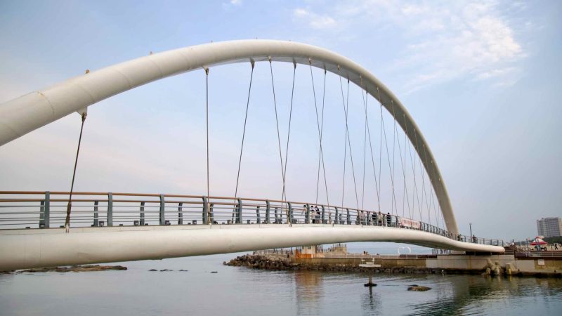 Graceful white arch of Gangmun Sotdae Bridge, offering seaside views over calm water.