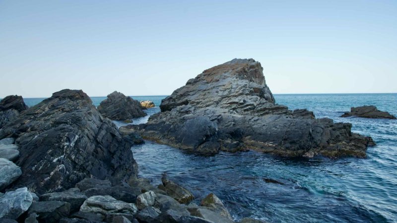 Craggy rock formations rise from the waters of the East Sea near Heonhwa Road.