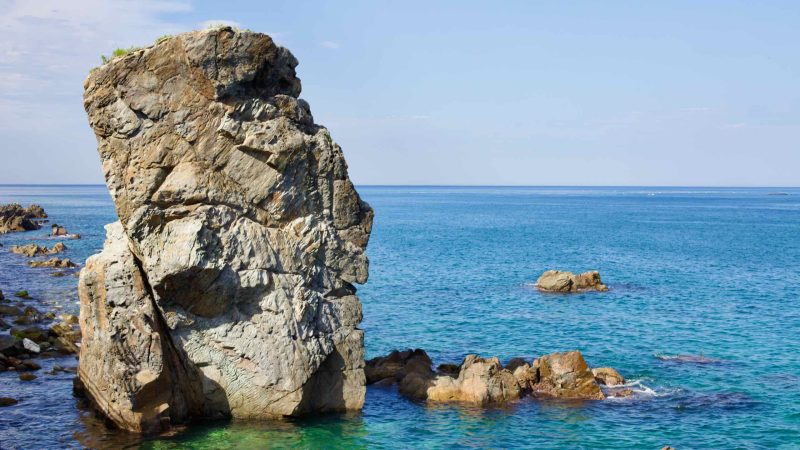 The imposing Black Rock, standing 15 meters tall off the coast of Mukho Port in the East Sea, earns its name from a legend of a crow laying its chick upon it.