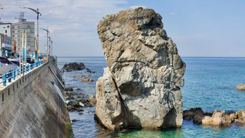 The imposing Black Rock, standing 15 meters tall off the coast of Mukho Port in the East Sea, earns its name from a legend of a crow laying its chick upon it.