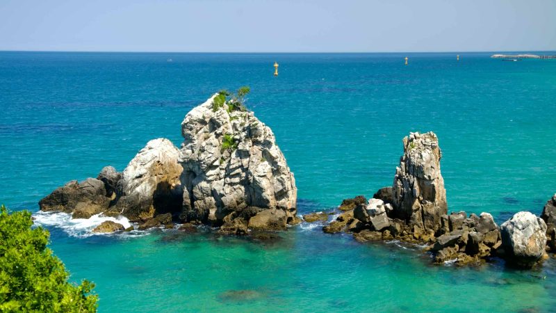 The striking formations of Brothers Rock rise from the clear turquoise waters of the East Sea near Chuam Beach.