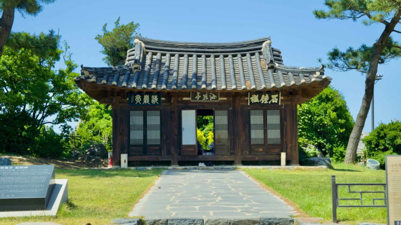 A front view of the historic Haeam Pavilion, showcasing traditional Korean architecture surrounded by pine trees.