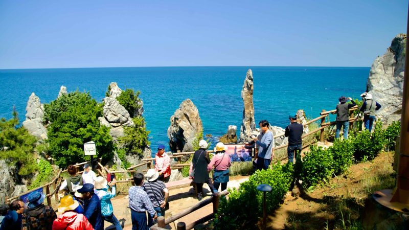 Tourists gather to view and photograph the iconic Chuam Candlestick Rock along the coast of the East Sea.