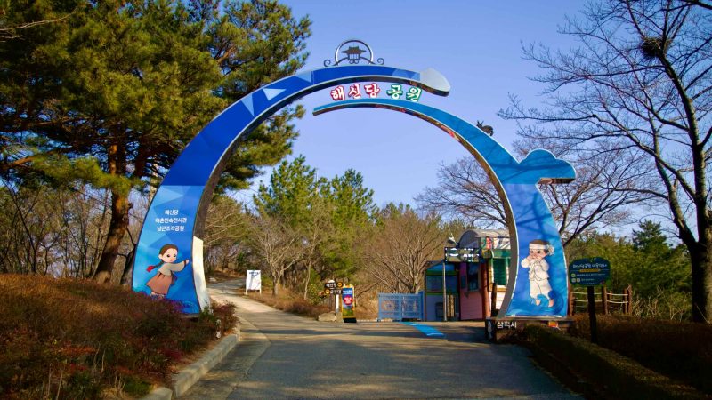 The entrance to Haesindang Park, marked by a circular blue arching gateway with the park's name prominently displayed on top.