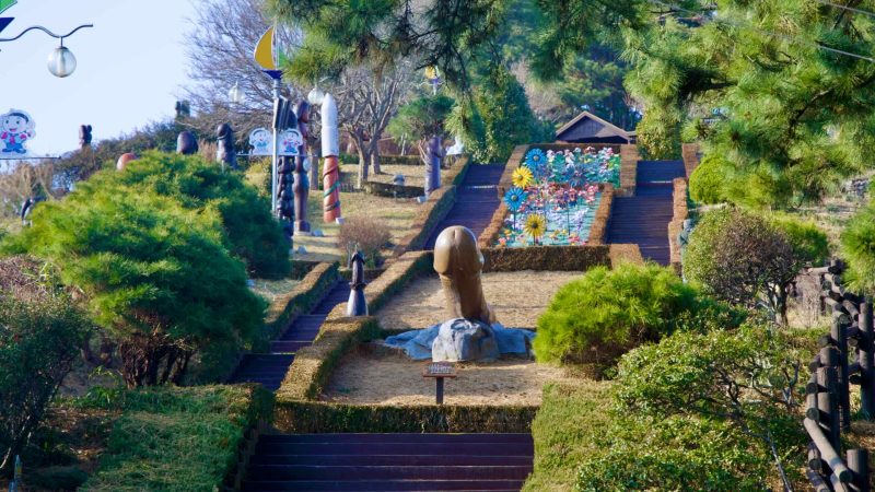 A panoramic overview of the tiered courtyard at Haesindang Park, featuring the central phallic sculpture and symmetrical steps on either side.