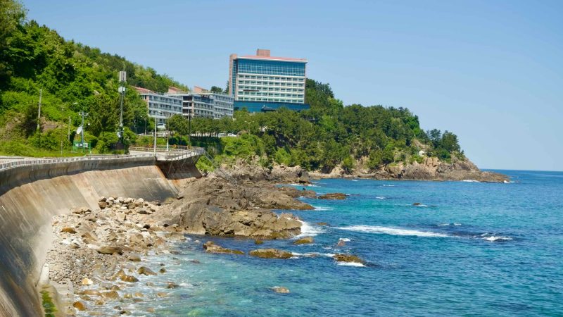 Samcheok City, South Korea - May 18th, 2024: A scenic view of the coastal road and the Felice Hotel along the rocky shoreline…