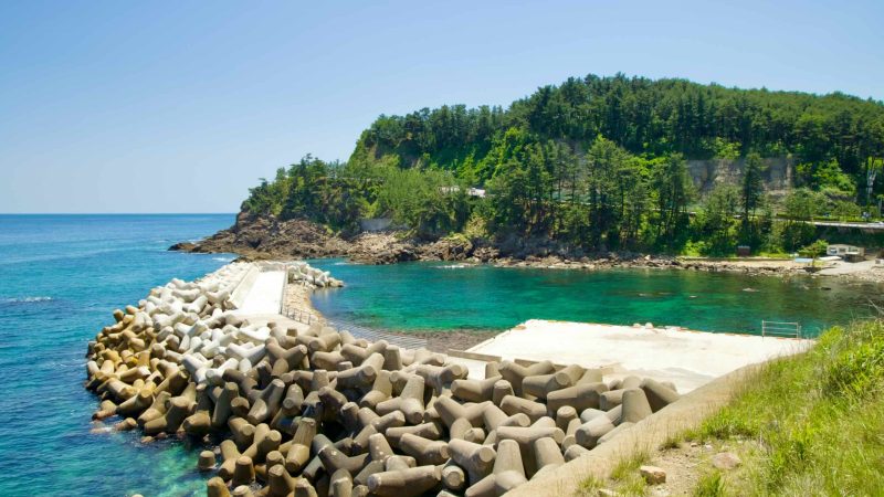 The waters and rocky coastline along Isabu Road, with a protective breakwater.