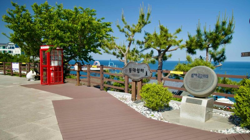 The courtyard of Mukho Lighthouse features historical markers, a slow post booth, and scenic views of the East Sea