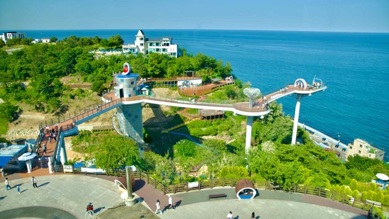 An elevated view of the Dojebigol Sky Valley, featuring the Haerang Observatory with its unique design and scenic walkway.