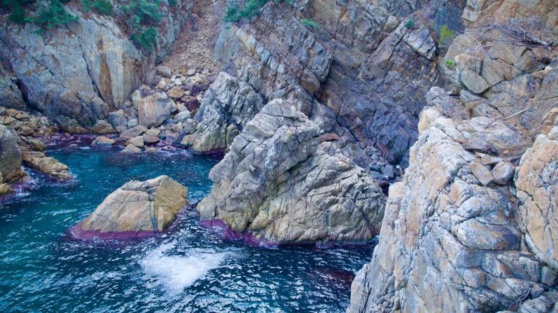Overlooking clear waters and a rocky coastline from the Chogok Yonggul Cave Hiking Trail, showcasing nature's unspoiled beauty.