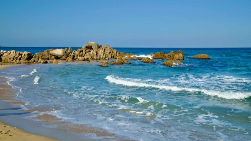 Gentle waves break against the rocks at Hajodae Beach, showcasing the serene beauty of the East Sea's clear waters and coastal charm.