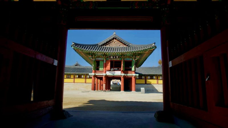 A framed view of Binilru Pavilion at Naksansa Temple, as seen through the ornate Four Heavenly Kings Gate, highlighting traditional Korean architecture.