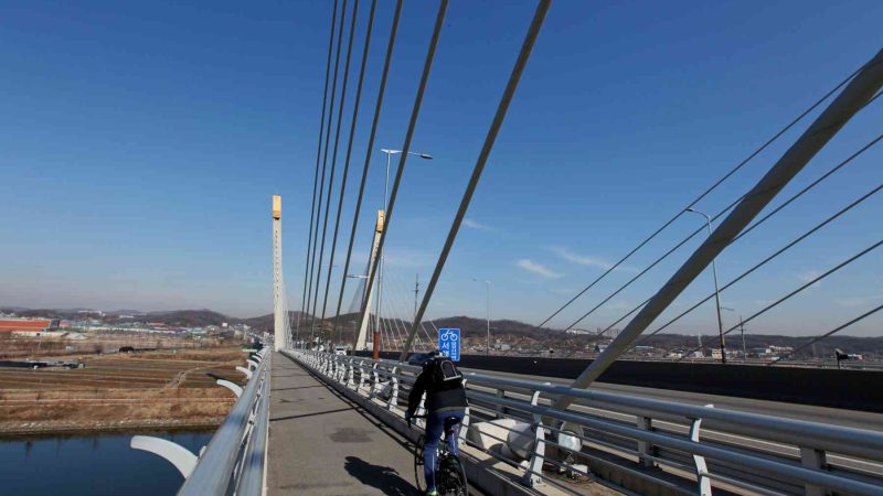 A cyclists crossing a bridge on the Ara Bike Path.