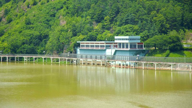 A picture of a raised cycling path and a water intake station that leads to Gangjeong Goryeong Weir (강정고령보) along the Nakdong River in Daegu, South Korea.