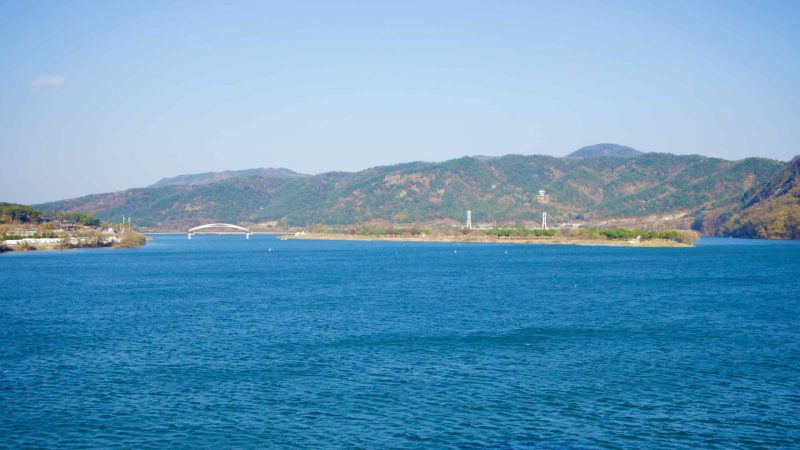 A picture of Gyeongcheon Island Park with the Nakdong River and Bibong Mountain (비봉산) in the background.