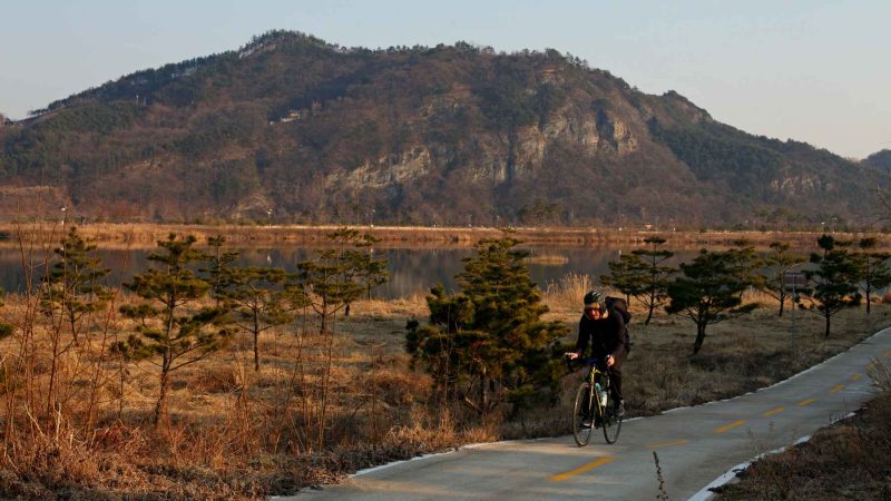 A cyclist rides the Nakdonggang Bike Path near Gyeongcheon Bridge in Sangju City, South Korea.