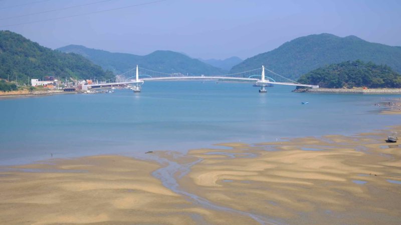 A view of the Haemaji Bridge stretching across the Seomjin River during low tide.