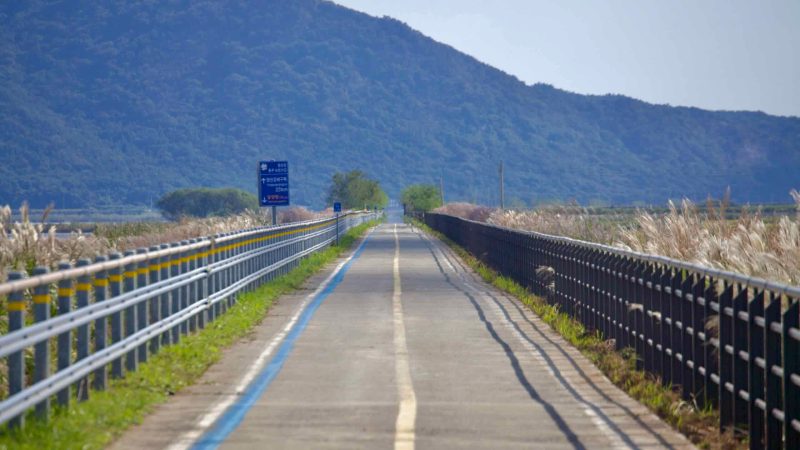 A straight stretch of the Yeongsangang Bike Path leads toward mountains.
