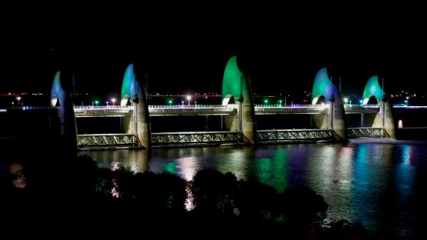 The Seungchon Weir on the Yeongsan River is bathed in green lighting at night.